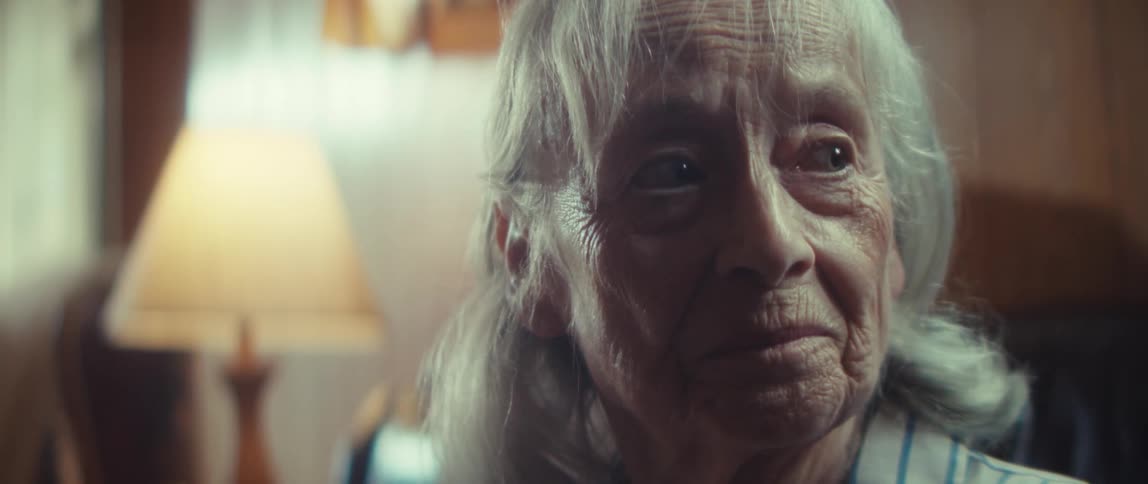 Close up portrait of a sad elderly woman sitting in a living room during daytime