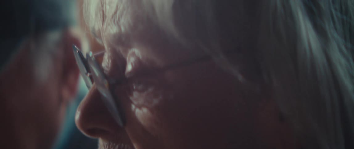 Two elderly people sitting in an indoor space