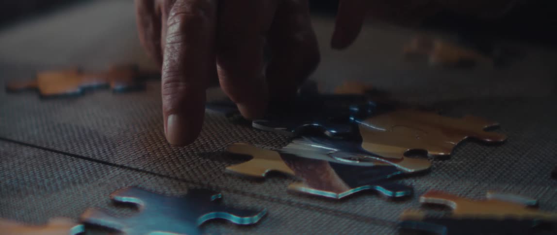 An elderly person works on a puzzle