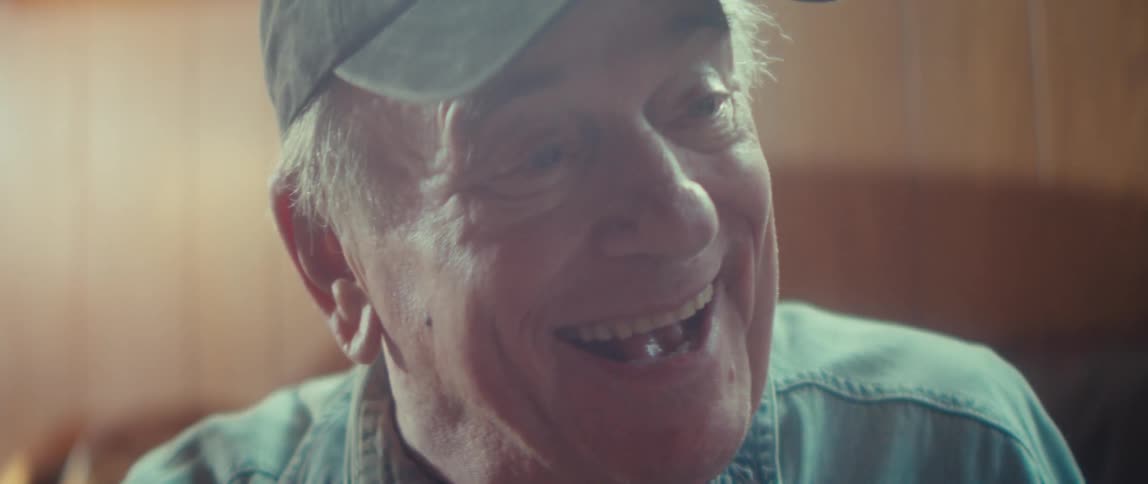 Elderly woman smiling joyfully beside someone in a lighthearted moment