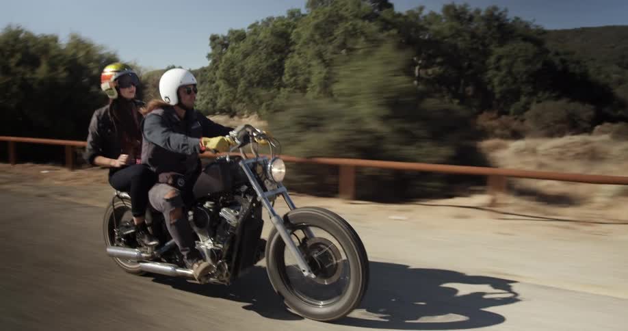 Man and woman ride a motorcycle in the countryside