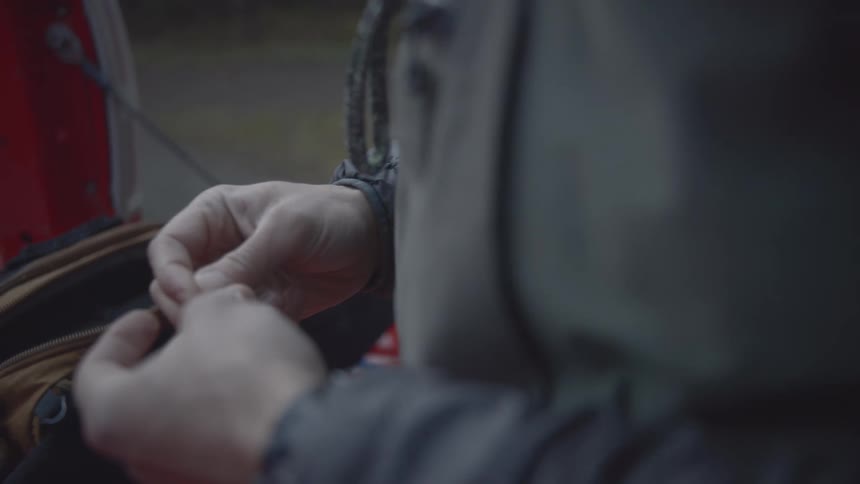 Person preparing a fishing hook with their hands
