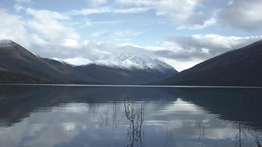 The reflection of nearby mountains can been seen on the surface of a large lake