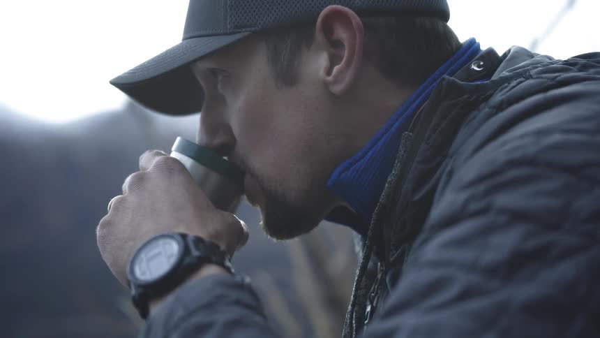 A man drinking hot tea in winter outdoors