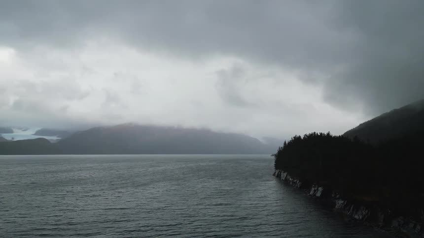 Heavy fog covers the mountains by the water