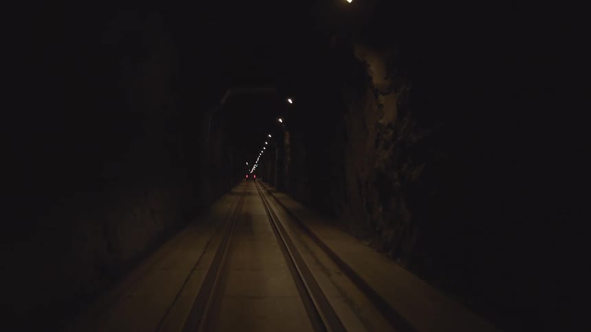The train travels through the dark tunnel