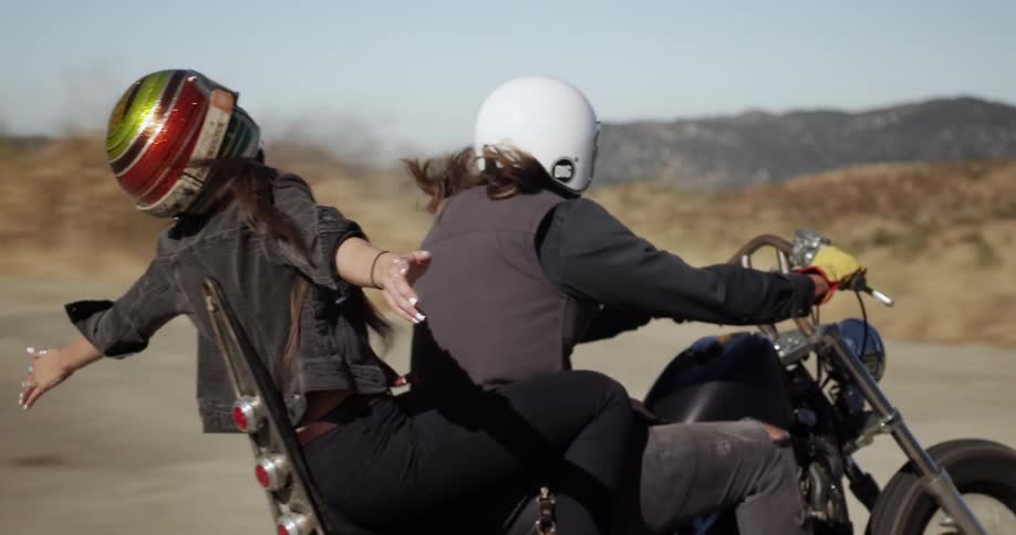 Two people riding a motorcycle on an open road