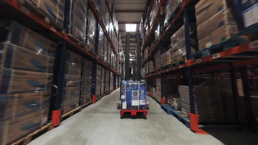Warehouse aisle with tall shelves filled with organized boxes