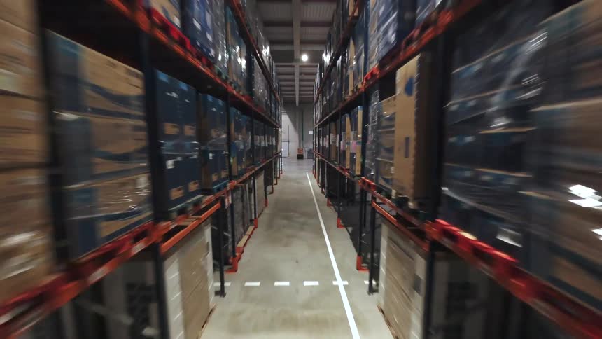 Industrial warehouse aisles with tall shelves filled with organized boxes