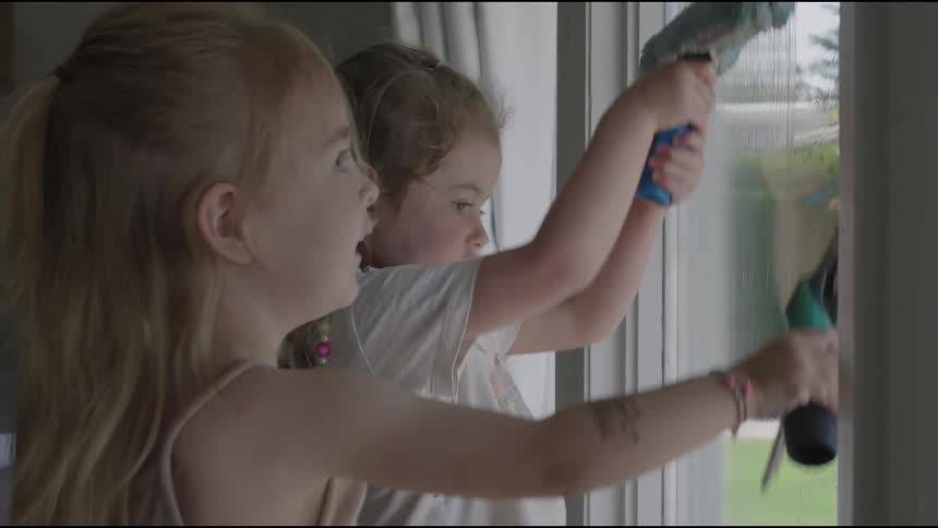 Children cleaning a window with squeegees