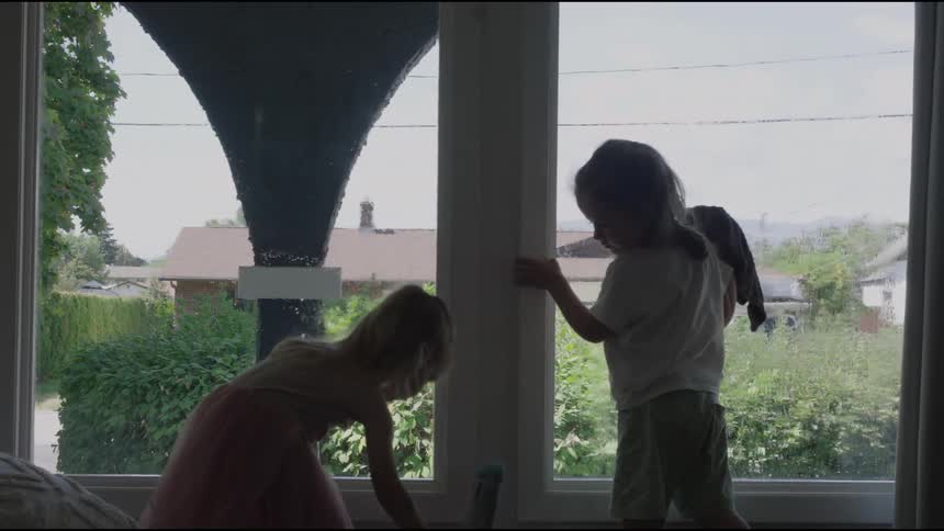 Two children are cleaning the windows in the home