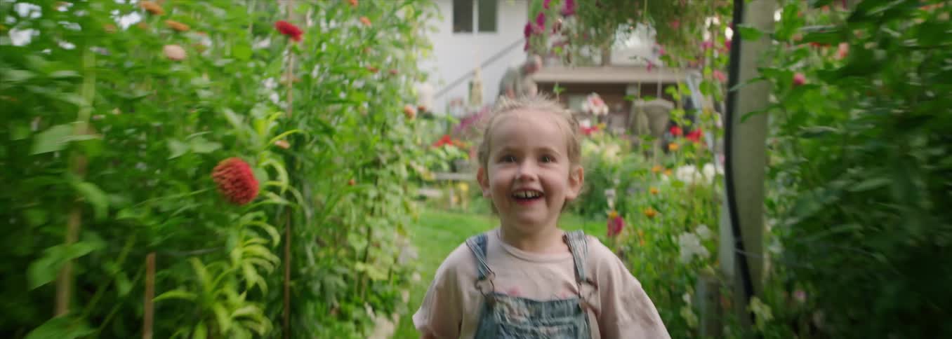 Smiling child running in a flower garden