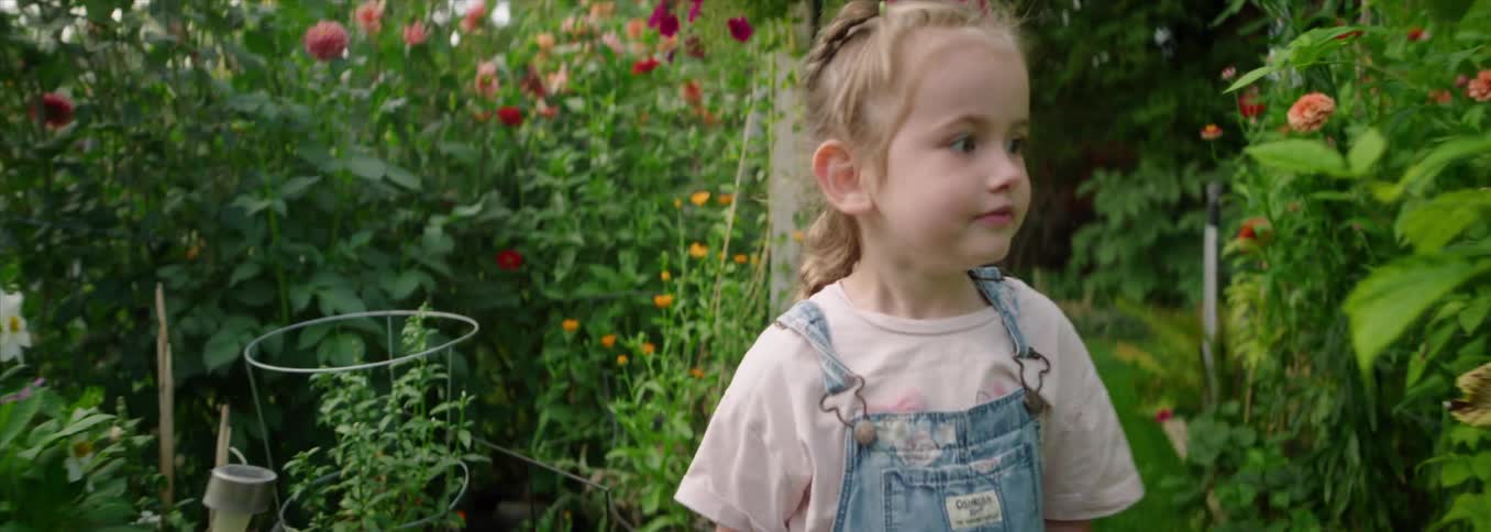Little girl running through a forest of flowers