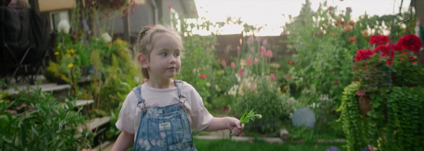 Child running along a flowerlined path in a garden