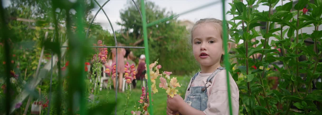 Child observing flowers in a blooming garden