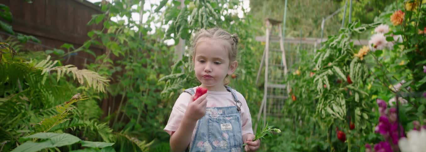 The child is eating watermelon in the garden