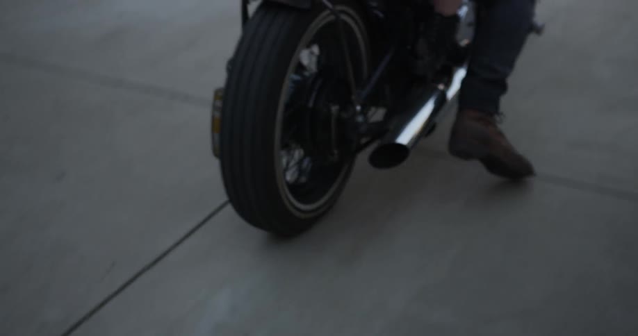 A man and woman riding on a motorcycle start off out of a driveway