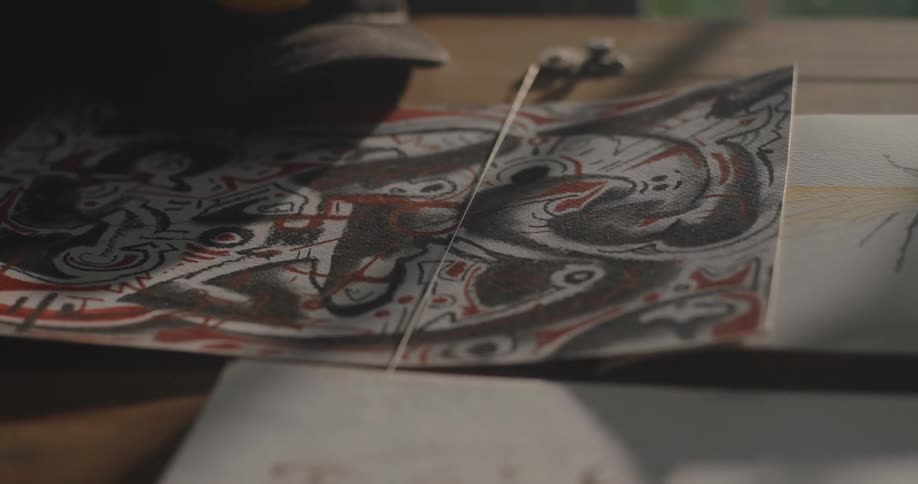 Abstract artistic drawing with curved shapes and black red and white colors on a table
