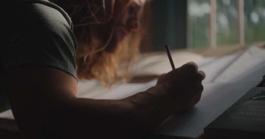 The man is drawing in the dark room