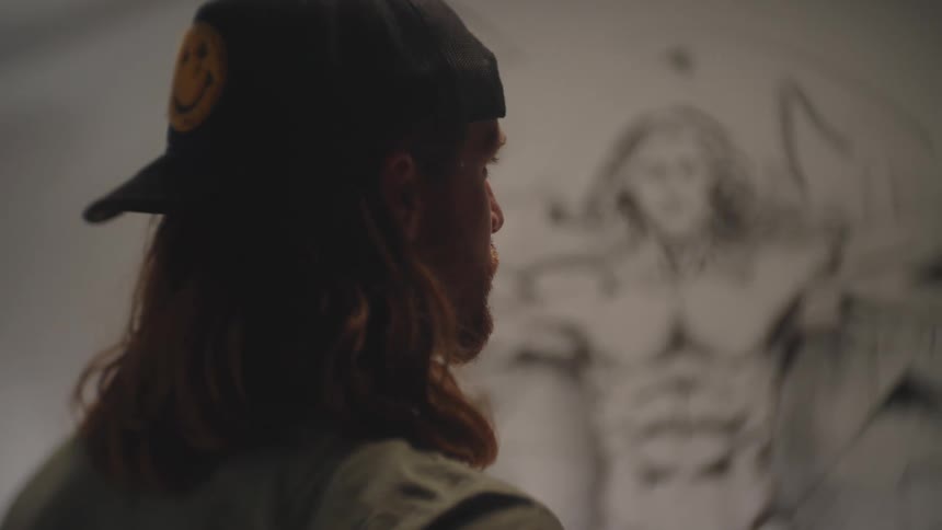 Man observing a large anatomical drawing on a wall