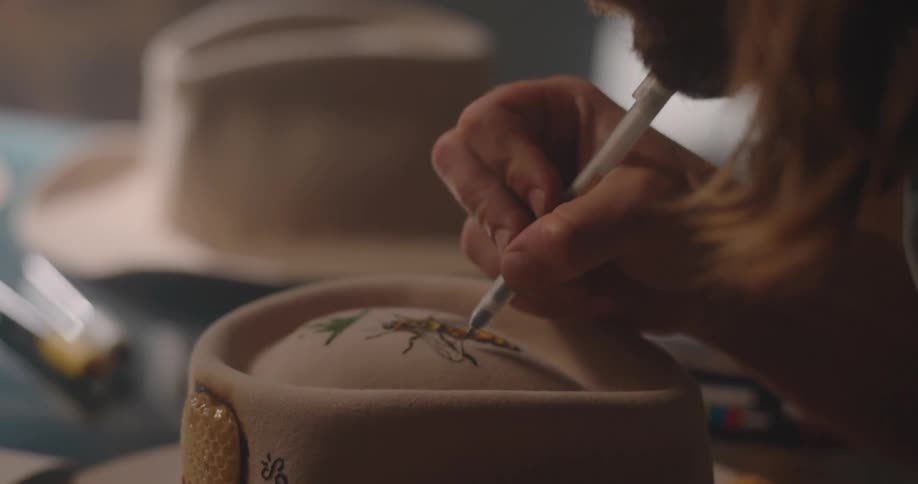 A man draws on a hat