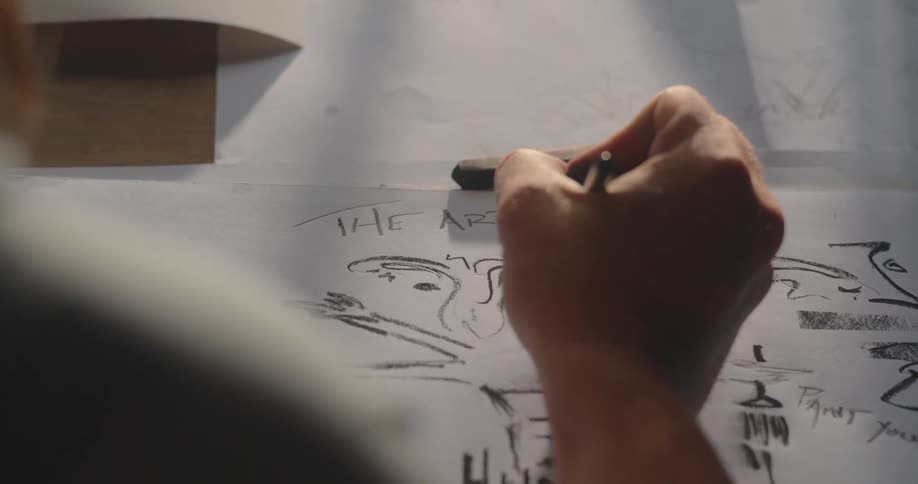 Person drawing a human figure on paper