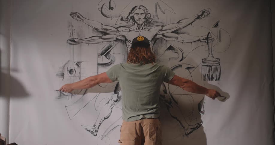 The man waves his arms around the artwork on the mural