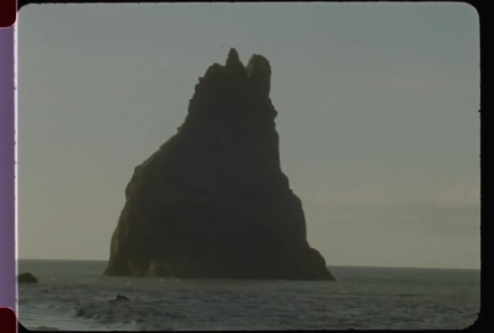 Large rock formation juts out in a body of water