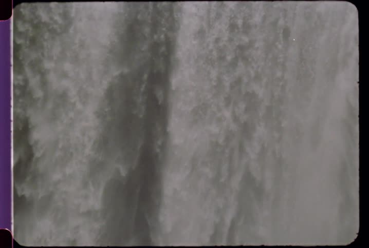 Large waterfall splashes into a body of water below