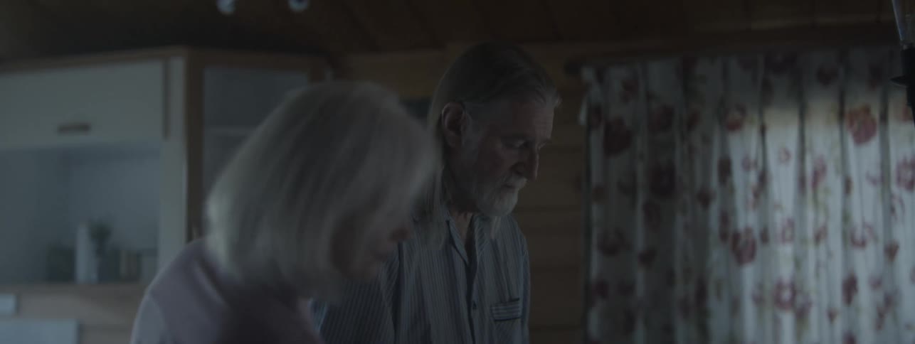 Elderly man with alzheimer's is being assisted back to the bedroom by a woman after wandering off at night