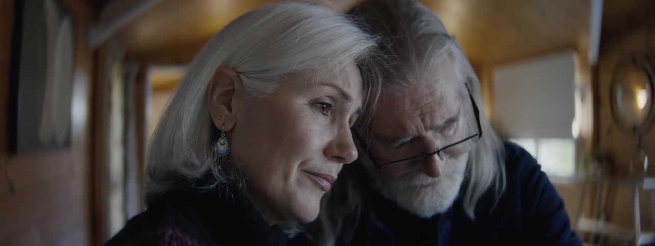 The woman is consoling a man at home