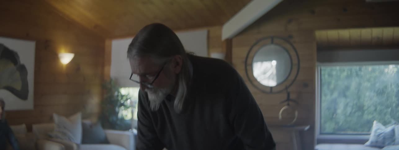 The man gets frustrated as he searches the living room for something