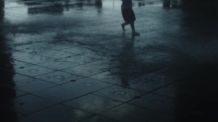Person running on a wet pavement on a rainy day
