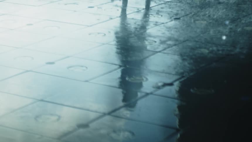 The person walks over the shooting water of the fountain