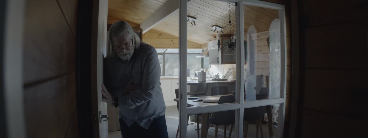 Man feeling unwell is supported by his wife at the house entrance
