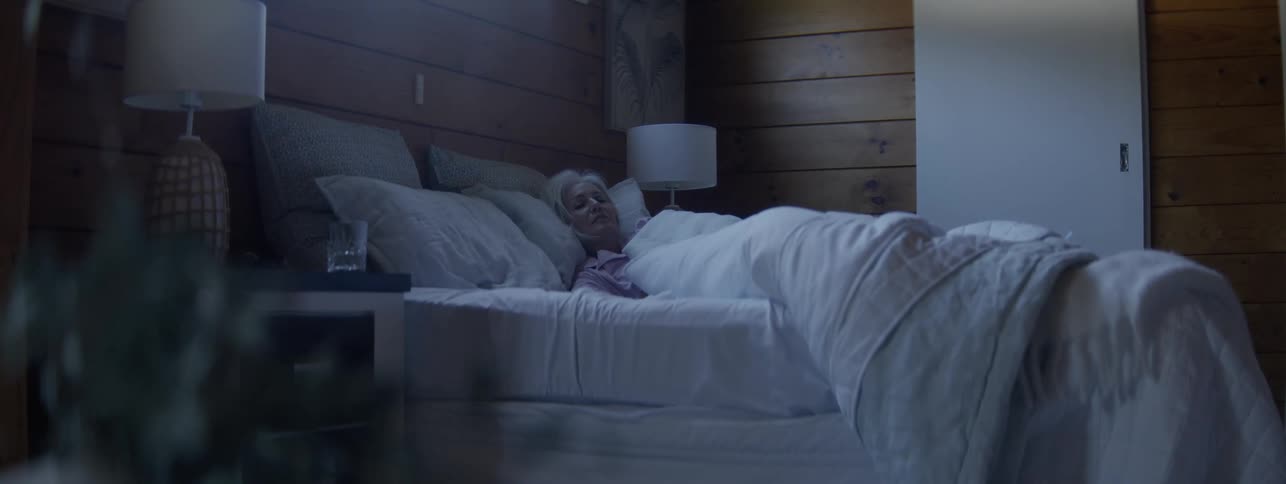 The woman is resting in her bed