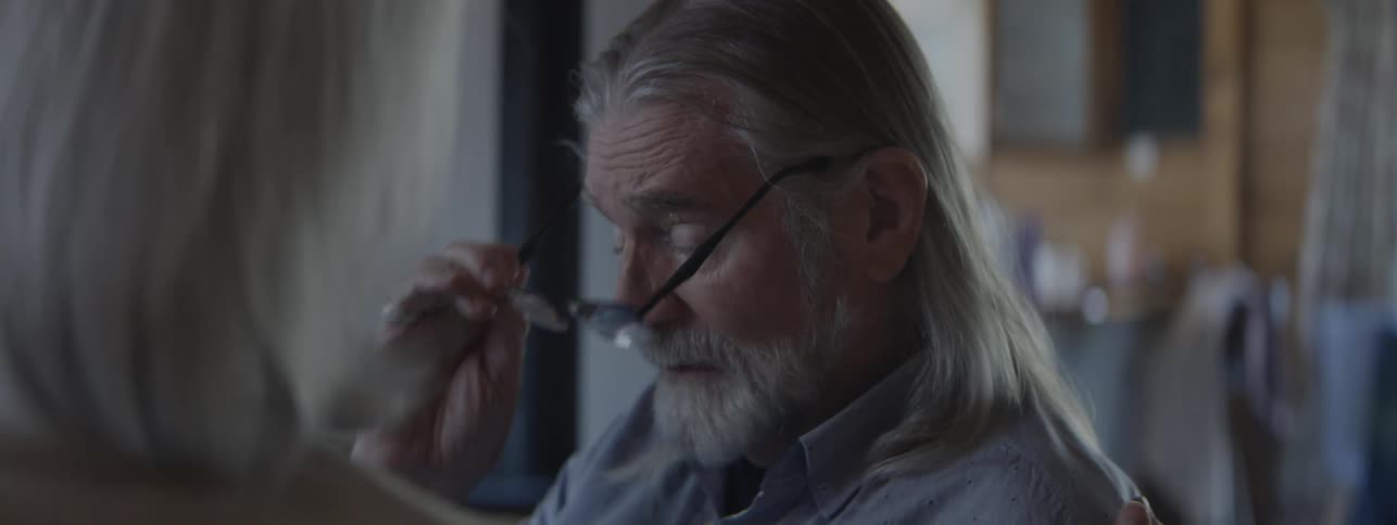 The sad man takes off his glasses