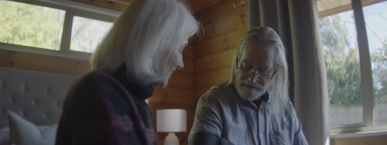 The man and woman are sitting and talking at home