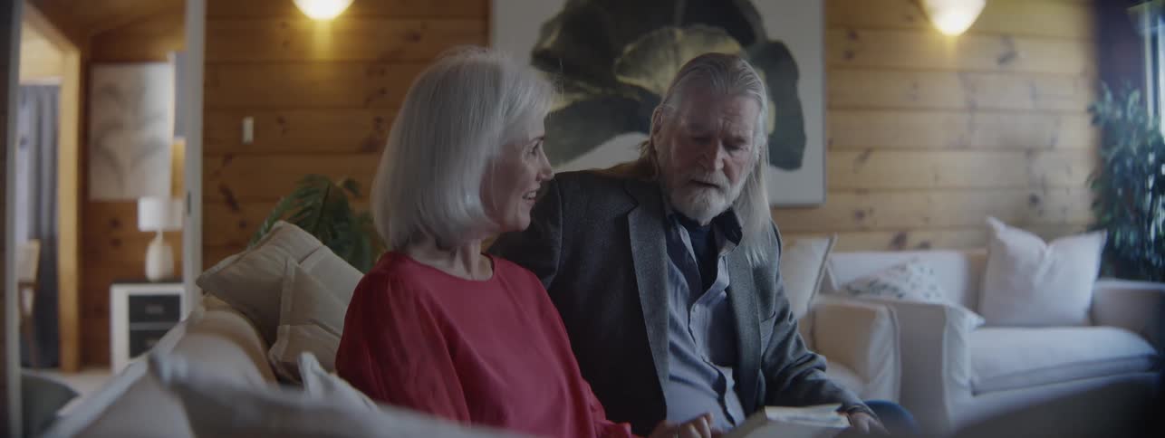 A couple talk and point towards a book together