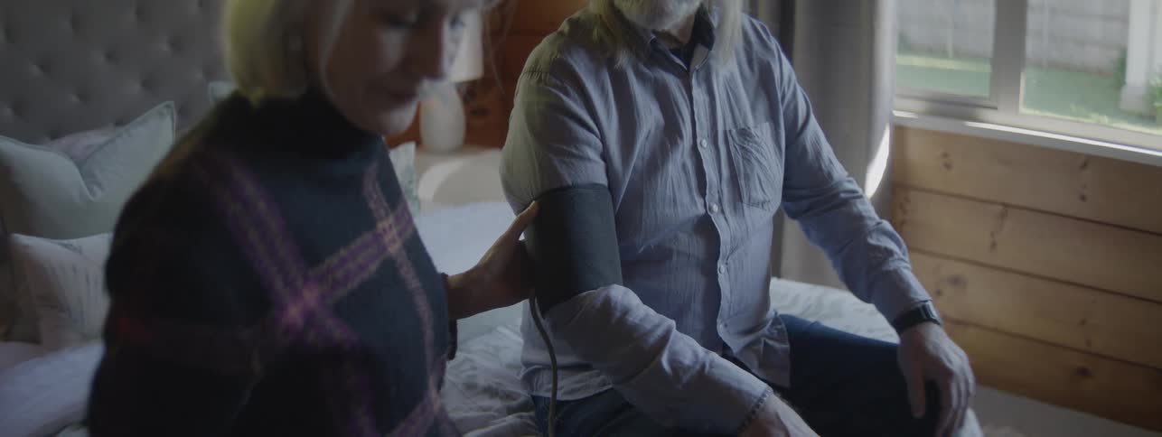The woman is testing the mans blood pressure