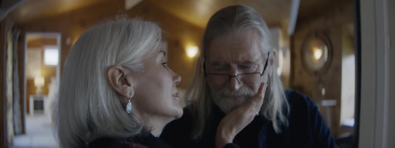 Elderly couple touches foreheads in an affectionate and silent gesture