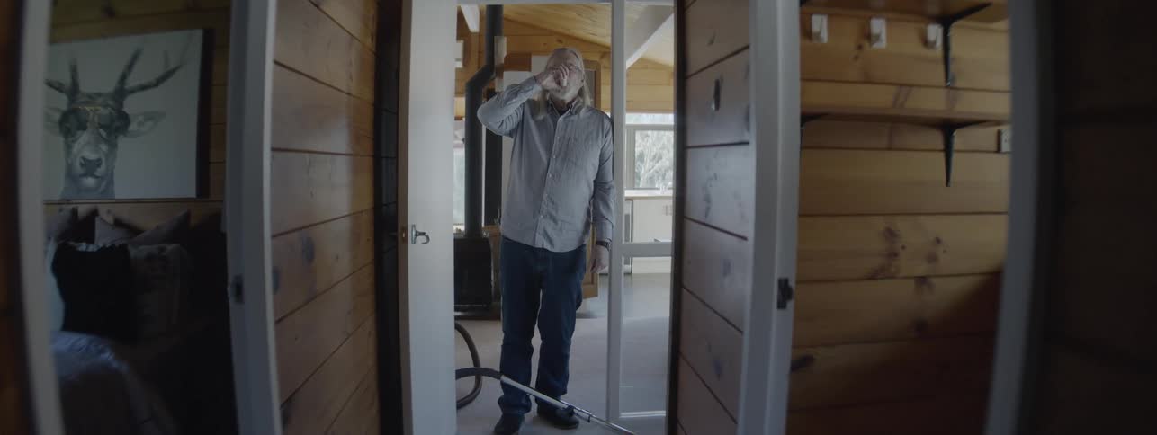 Man cleaning the house with a vacuum while using an oxygen inhaler