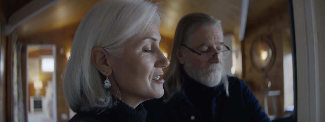 Close up of a middle aged man and woman conversing in a room during daytime