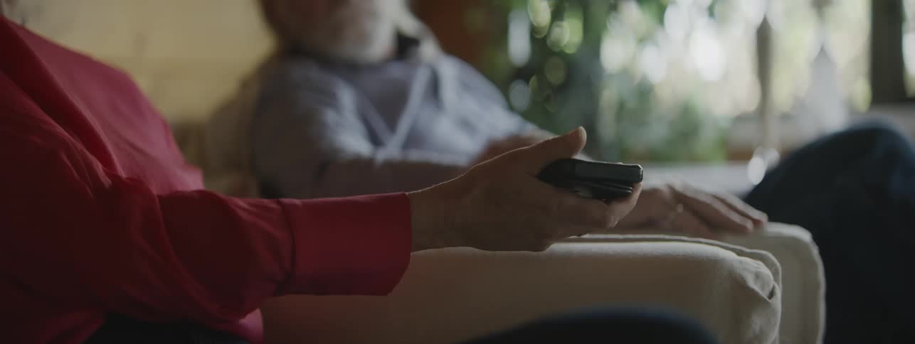 Female hands with rings hold and use a smartphone while sitting and showing it to a person next to her