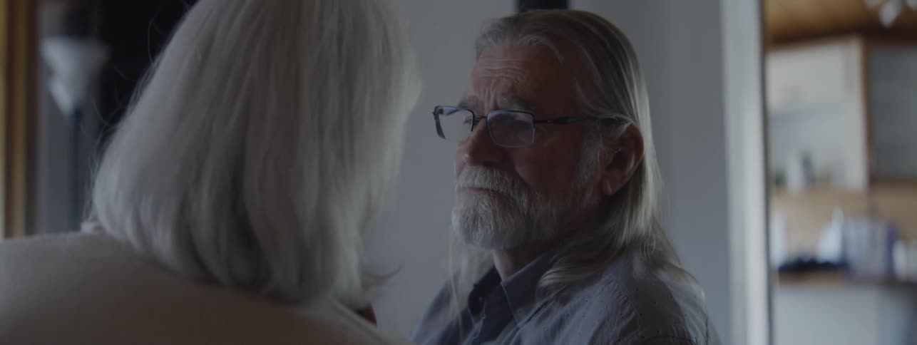 Elderly couple exchanging a serious look in a home setting