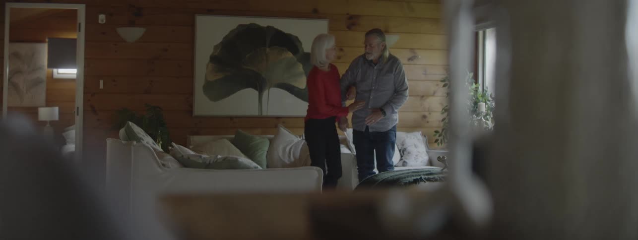The couple get up from the couch and dance