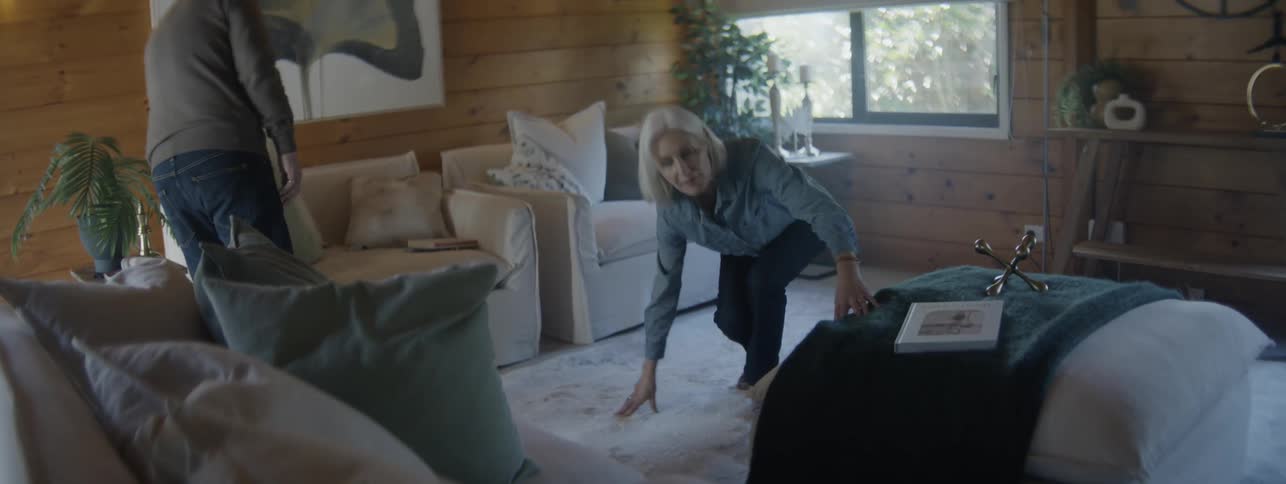 Older couple searches the living room for a lost item during the daytime