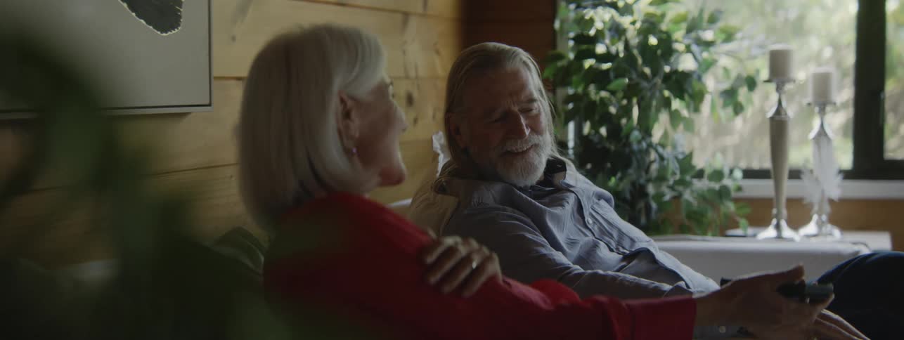 The man and woman talk and get up off the couch