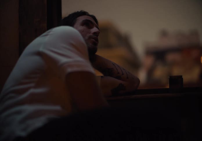 Pensive man leaning against the window at night