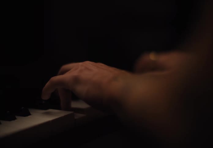 Person playing piano and a woman crawling on the floor